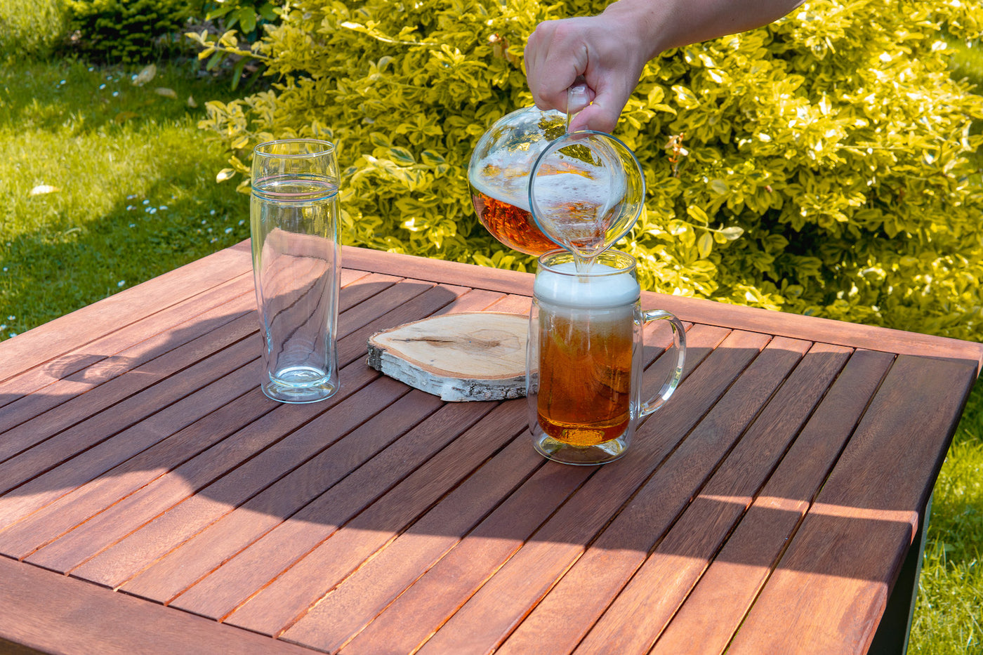 Skleněné pivní půllitry Simax s uchem a bez ucha na dřevěném zahradním stole
