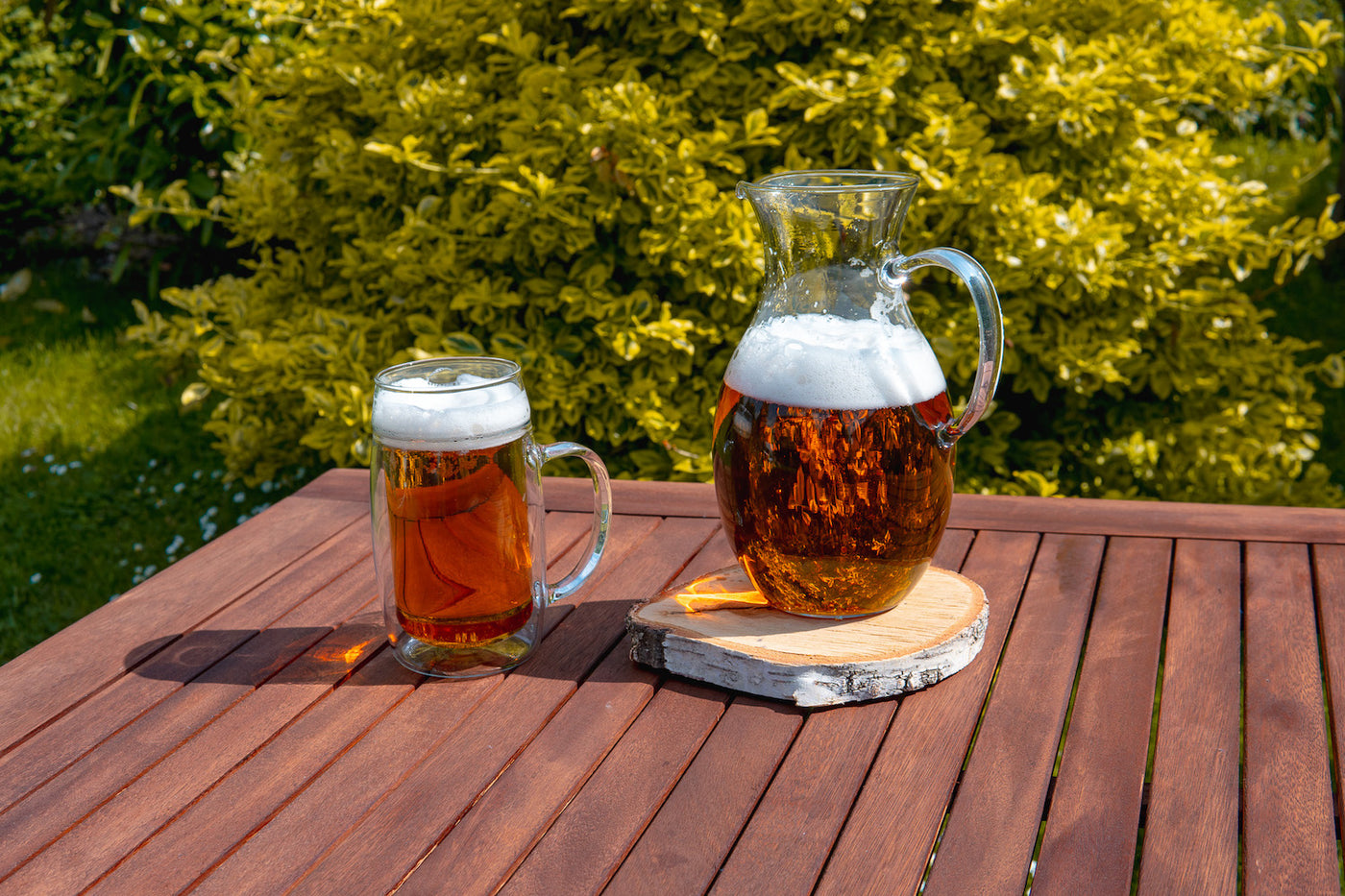 Skleněný džbán na pivo a půllitr na pivo na venkovním stole