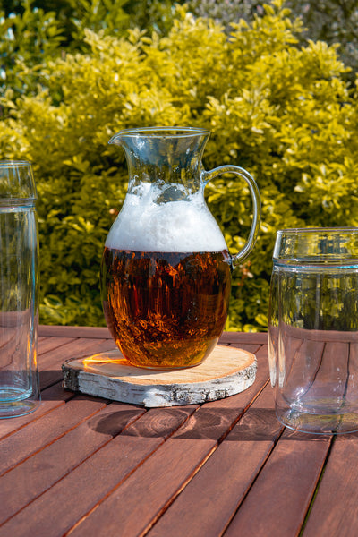 Skleněný džbán na pivo Simax Klasik na stole mezi skleněnými půllitry