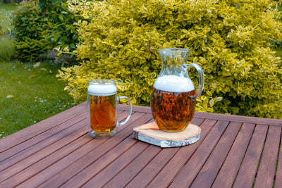Skleněný pivní půllitr dvoustěnný Simax na dřevěném zahradním stole