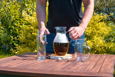Skleněný půllitr na pivo bez ucha Simax se džbánem na zahradním stole