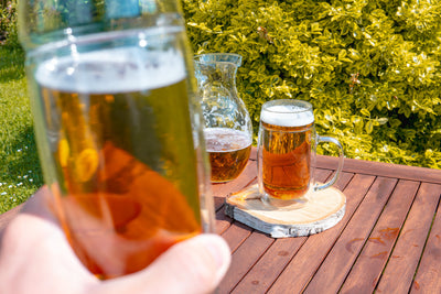 Skleněný dvoustěnný půllitr Simax na pivo s uchem na zahradním stole