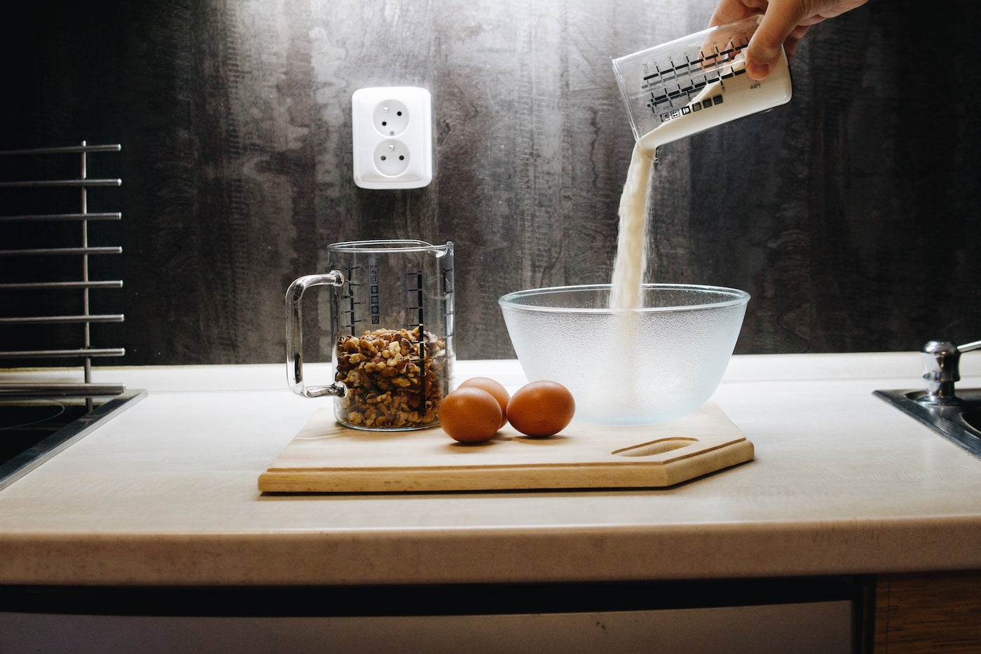 Kuchyňská skleněná odměrka s ořechy a skleněná mísa Simax Frozen při přípravě těsta