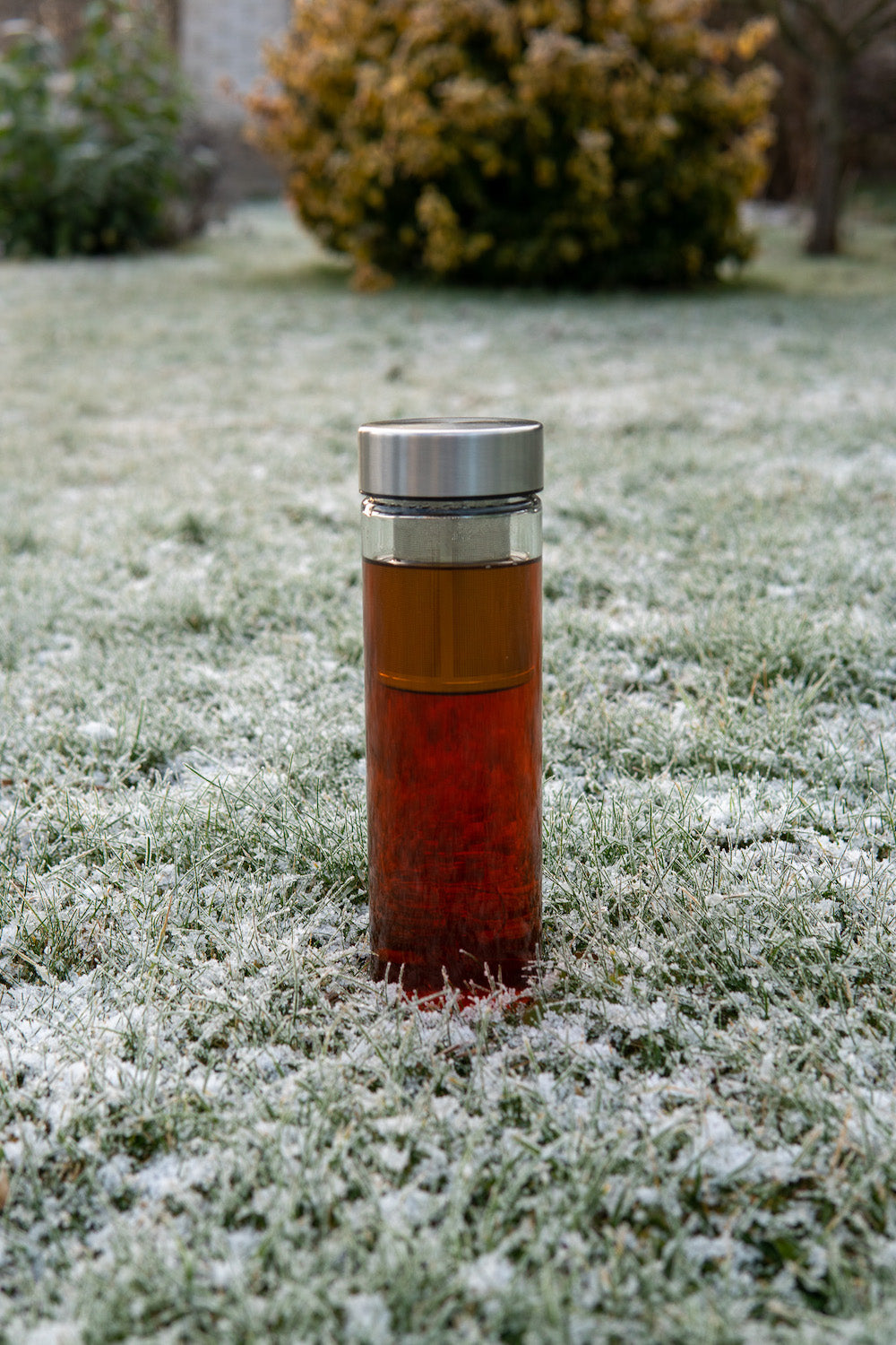 Skleněná láhev na vodu Simax 0,5 l se sítkem na zmrzlém trávníku