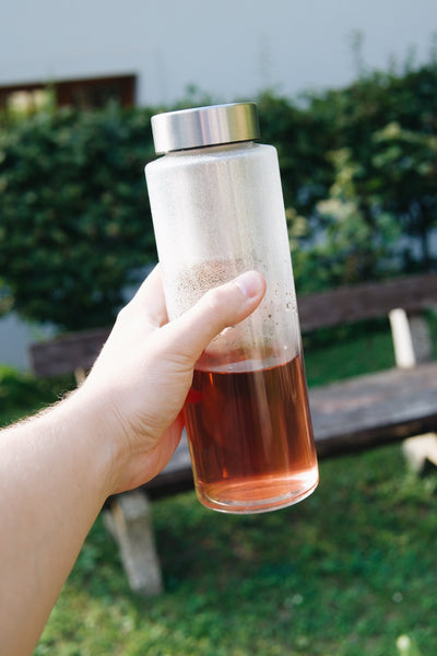 Skleněná láhev na vodu Simax 1 litr se sítkem na zahradě