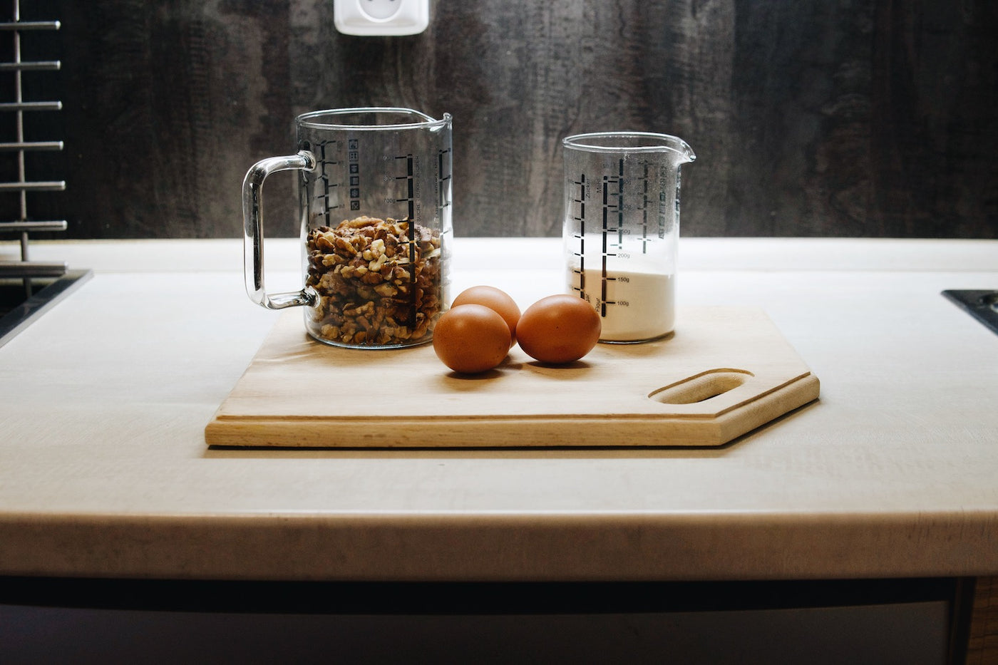 Skleněné kuchyňské odměrky Simax na kuchyňské lince s ořechy a vejci