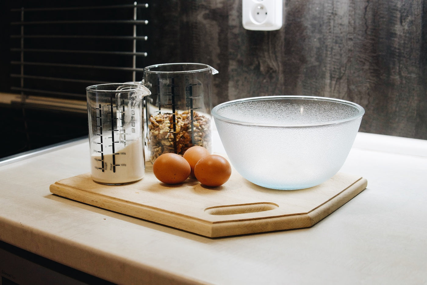 Skleněné kuchyňské odměrky Simax s ořechy a moukou a skleněná mísa Simax Frozen na kuchyňské lince