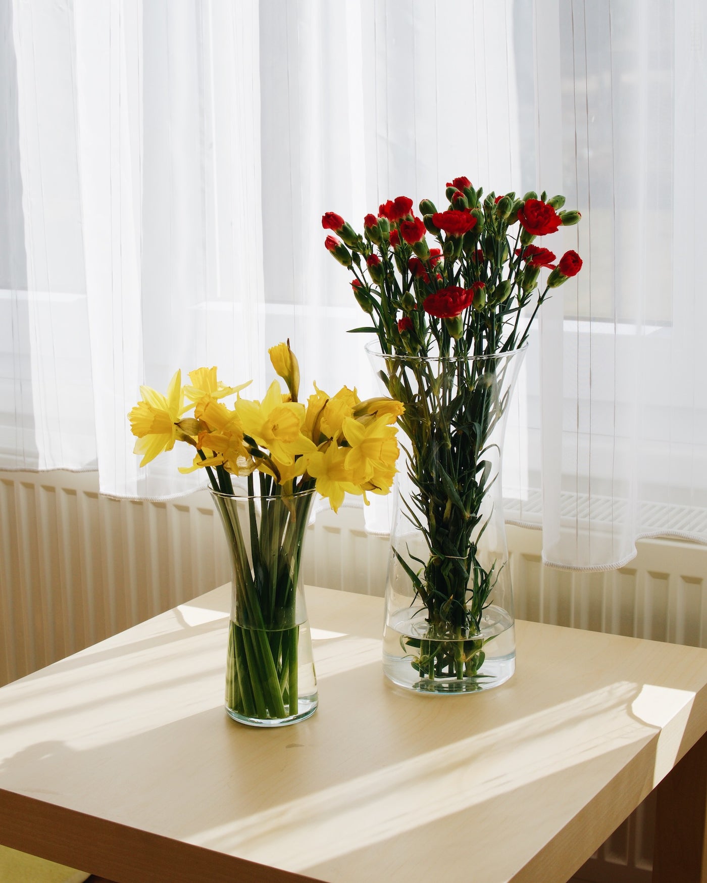 Skleněné vázy Simax Rose s květinami na stole
